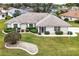 An eye-level aerial view of a home with a manicured front lawn and tastefully trimmed shrubbery at 21721 Loch Haven Pass, Leesburg, FL 34748