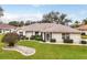 Charming single-story home featuring a well-manicured lawn, tasteful landscaping, and neutral exterior paint at 21721 Loch Haven Pass, Leesburg, FL 34748