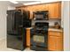 Black appliances and oak cabinets in this kitchen at 21721 Loch Haven Pass, Leesburg, FL 34748