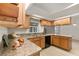 Well-lit kitchen with wooden cabinets, granite countertops, and stainless steel sink at 21721 Loch Haven Pass, Leesburg, FL 34748