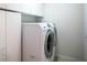 Laundry room equipped with a washer, dryer, and ample storage cabinets at 21721 Loch Haven Pass, Leesburg, FL 34748