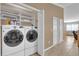 Bright laundry room with washer, dryer, and ample shelving at 2214 Quinn Ln, The Villages, FL 32162