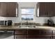 Clean kitchen features dark cabinetry, a double sink, and a window overlooking a backyard view at 238 Oak Lane Cir, Ocala, FL 34472