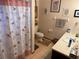 Bathroom with toilet, sink, and floral shower curtain at 2403 County Road 416N, Lake Panasoffkee, FL 33538