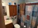 Clean bathroom with shower/tub combo and wood cabinets at 2403 County Road 416N, Lake Panasoffkee, FL 33538