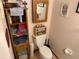 Clean bathroom with toilet, shelving, and linen cabinet at 2403 County Road 416N, Lake Panasoffkee, FL 33538