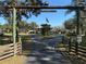 Home with a long driveway and wooden entrance gate at 2403 County Road 416N, Lake Panasoffkee, FL 33538