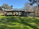 Metal-roofed equipment shed with covered workspace and lawn at 2403 County Road 416N, Lake Panasoffkee, FL 33538