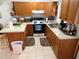 L-shaped kitchen with wood cabinets at 2403 County Road 416N, Lake Panasoffkee, FL 33538