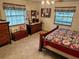 Spacious main bedroom with wood furniture and large windows at 2403 County Road 416N, Lake Panasoffkee, FL 33538