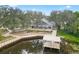 Picturesque clubhouse with covered porch, fishing dock, and tranquil pond create an idyllic waterfront retreat at 2484 Lynette Ave, The Villages, FL 32163