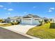 Two-car garage home with white exterior and green lawn at 2484 Lynette Ave, The Villages, FL 32163