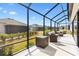 Relaxing screened patio with wicker furniture and backyard view at 2484 Lynette Ave, The Villages, FL 32163