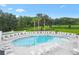 Community pool features chairs for residents and guests, views of pond and mature trees create a relaxed ambiance at 2484 Lynette Ave, The Villages, FL 32163