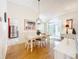 Spacious dining area with white table and chairs, hardwood floors and kitchen view at 25107 Meriweather Rd, Leesburg, FL 34748