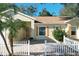 Front view of a light yellow house with orange shutters and a white picket fence at 25107 Meriweather Rd, Leesburg, FL 34748