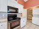 Bright kitchen with stainless steel appliances and white cabinets at 25107 Meriweather Rd, Leesburg, FL 34748