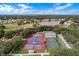 Aerial view of tennis and pickleball courts near a lake at 25236 River Crest Dr, Leesburg, FL 34748