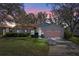 Evening view of a single-story house with a pink garage door at 25236 River Crest Dr, Leesburg, FL 34748