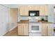 White appliances and light-colored cabinets in this kitchen at 25236 River Crest Dr, Leesburg, FL 34748