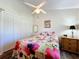 Bright bedroom with floral bedding, double closets, and ceiling fan at 25339 Hibiscus St, Leesburg, FL 34748