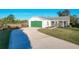 House with green garage door and curved driveway at 25339 Hibiscus St, Leesburg, FL 34748