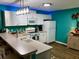 Modern kitchen with white cabinets and teal walls at 2552 Mariel Way, The Villages, FL 32162