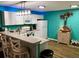 Modern kitchen with white cabinets and teal walls at 2552 Mariel Way, The Villages, FL 32162