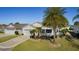 Aerial view of a white house with a palm tree and well-manicured lawn at 2565 Edenville Path, The Villages, FL 32162