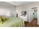 Bright bedroom with a leafy green comforter and en-suite bathroom at 2565 Edenville Path, The Villages, FL 32162