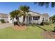 Front view of a white house with palm trees and a well-manicured lawn at 2565 Edenville Path, The Villages, FL 32162