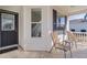 Front porch with dark brown door and two light brown chairs at 2565 Edenville Path, The Villages, FL 32162