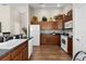 Modern kitchen with white appliances and wood cabinets at 2565 Edenville Path, The Villages, FL 32162