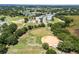 Aerial view of a neighborhood baseball field, with houses and a lake in the distance at 26154 Newcombe Cir, Leesburg, FL 34748