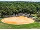 Overhead view of a well-maintained baseball field with dugouts and surrounding trees at 26154 Newcombe Cir, Leesburg, FL 34748