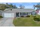 One-story home with gray siding, landscaped yard, and attached garage at 26154 Newcombe Cir, Leesburg, FL 34748