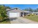 Gray siding, attached garage, and lush green lawn at 26154 Newcombe Cir, Leesburg, FL 34748