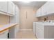 Laundry room with washer, dryer, and white cabinets at 26154 Newcombe Cir, Leesburg, FL 34748