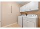 Laundry room with washer, dryer, and white cabinets at 26154 Newcombe Cir, Leesburg, FL 34748