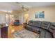 Living room with hardwood floors, sectional sofa and ceiling fan at 26154 Newcombe Cir, Leesburg, FL 34748