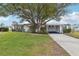 Single-story home with carport, mature landscaping, and large tree in front at 2753 Vindale Rd, Tavares, FL 32778