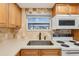 Kitchen features light wood cabinets, a white microwave, and a black sink at 2753 Vindale Rd, Tavares, FL 32778