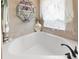 Relaxing bathroom with corner soaking tub, tile flooring, and decorative shelving at 2775 Sw 158Th St, Ocala, FL 34473