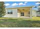 Rear view of house with screened patio and grassy yard at 29567 Caspian St, Leesburg, FL 34748