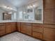 Double vanity bathroom with wood cabinets and tile floors at 3144 Blackstock Way, The Villages, FL 32163