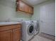 Laundry room with washer, dryer, and cabinets at 3144 Blackstock Way, The Villages, FL 32163