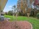 Landscaped backyard with mature trees and shrubs at 353 Ranchwood Dr, Leesburg, FL 34748