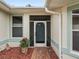 Front entry featuring a teal door and red flower pot at 353 Ranchwood Dr, Leesburg, FL 34748