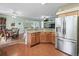 Kitchen with island, stainless steel fridge, and view into dining area at 353 Ranchwood Dr, Leesburg, FL 34748