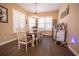 Bright dining room with wood table and white chairs, view to kitchen at 41516 Saddle Ridge Ln, Weirsdale, FL 32195